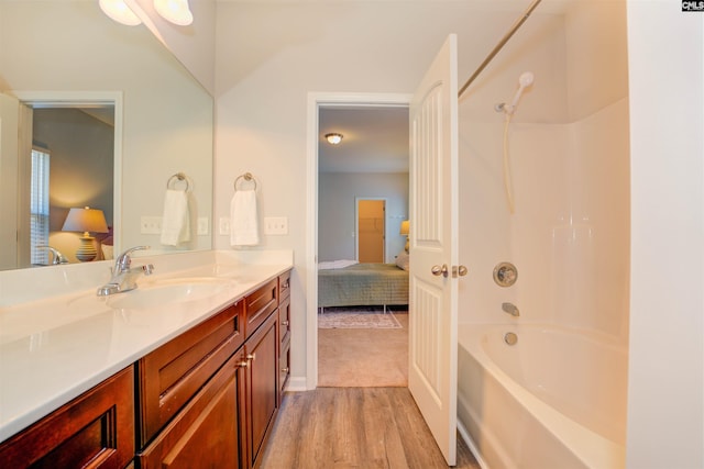 bathroom featuring shower / bathtub combination, ensuite bath, vanity, and wood finished floors