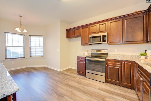 kitchen with decorative light fixtures, light wood-type flooring, a chandelier, and stainless steel appliances