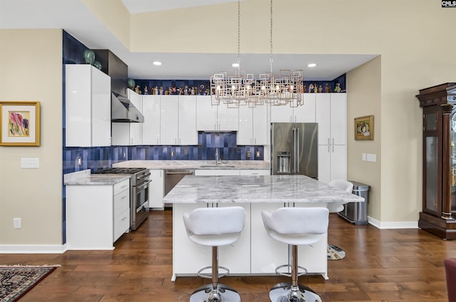 kitchen featuring a kitchen breakfast bar, tasteful backsplash, wall chimney range hood, high end appliances, and a chandelier
