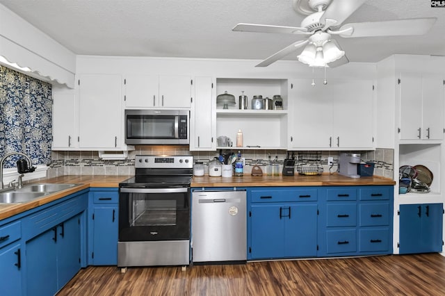 kitchen with tasteful backsplash, appliances with stainless steel finishes, dark wood-type flooring, and a sink