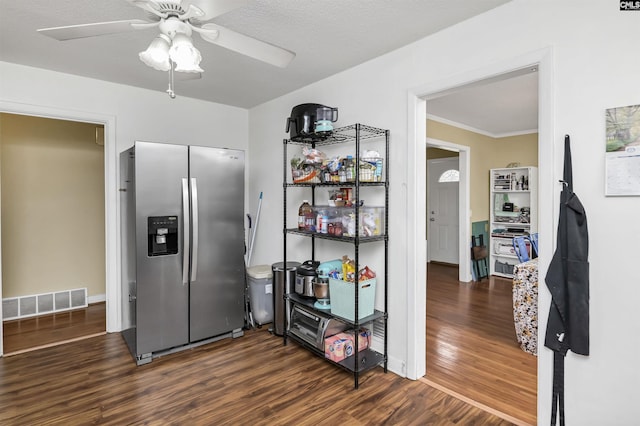 kitchen featuring visible vents, dark wood-type flooring, ornamental molding, stainless steel fridge with ice dispenser, and ceiling fan