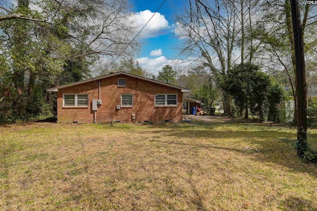 view of home's exterior featuring crawl space, a lawn, and brick siding