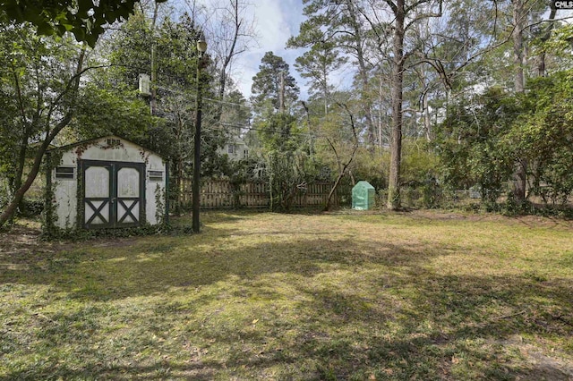 view of yard with a storage shed, an outdoor structure, and fence