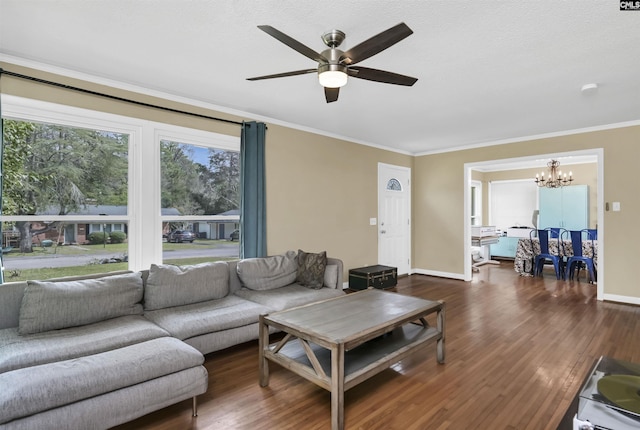 living room with baseboards, crown molding, dark wood-style flooring, and ceiling fan with notable chandelier