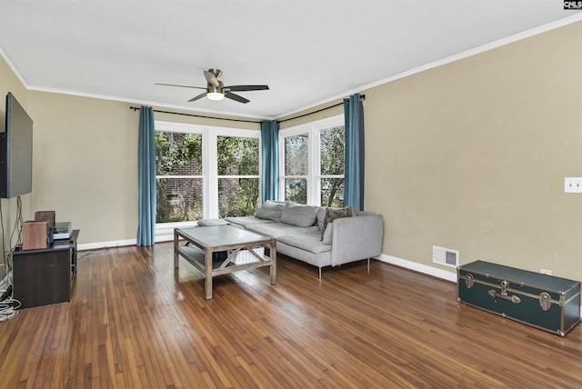 living room featuring dark wood finished floors, crown molding, baseboards, and ceiling fan