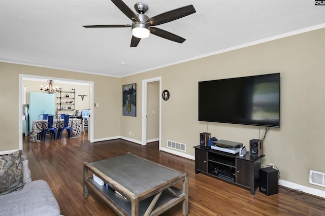 living room with ceiling fan with notable chandelier, wood finished floors, visible vents, and ornamental molding