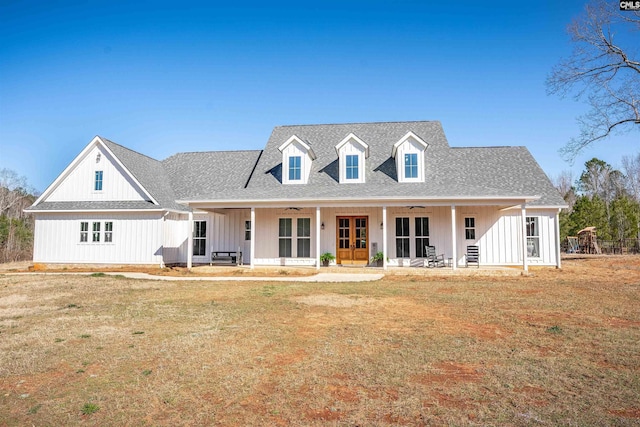 view of front facade featuring a front yard, covered porch, board and batten siding, and ceiling fan