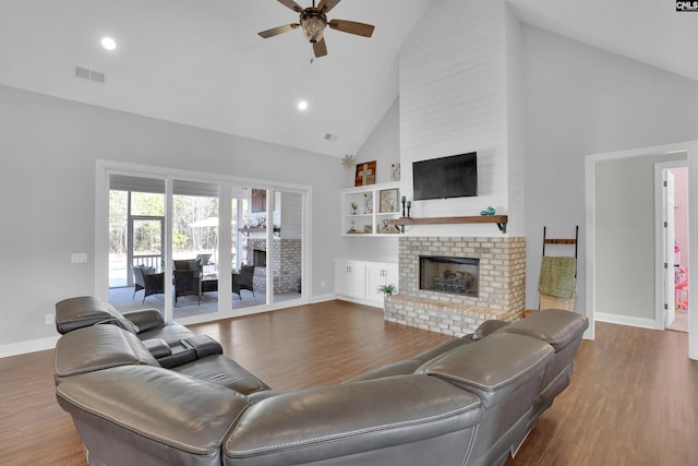 living room featuring dark wood-style floors, a fireplace, high vaulted ceiling, and ceiling fan