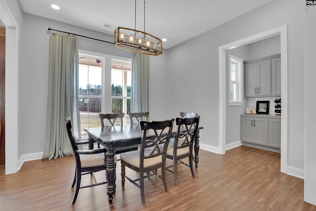 dining room with plenty of natural light, an inviting chandelier, and wood finished floors