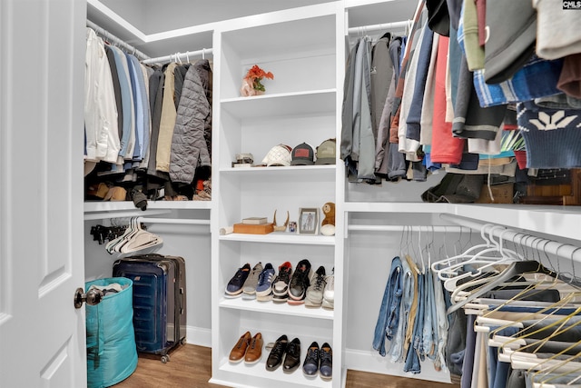 walk in closet with wood finished floors