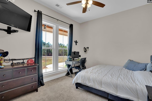 bedroom with visible vents, light colored carpet, baseboards, and ceiling fan