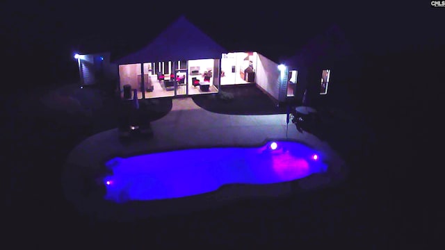 pool at night with a patio area