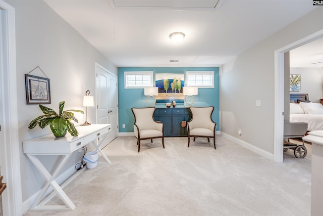 sitting room with attic access, visible vents, baseboards, and carpet floors