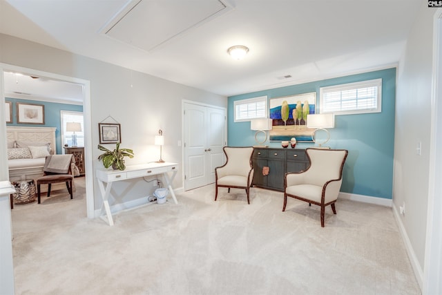 sitting room with attic access, baseboards, and carpet floors