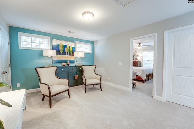 sitting room featuring a wealth of natural light, visible vents, and carpet flooring