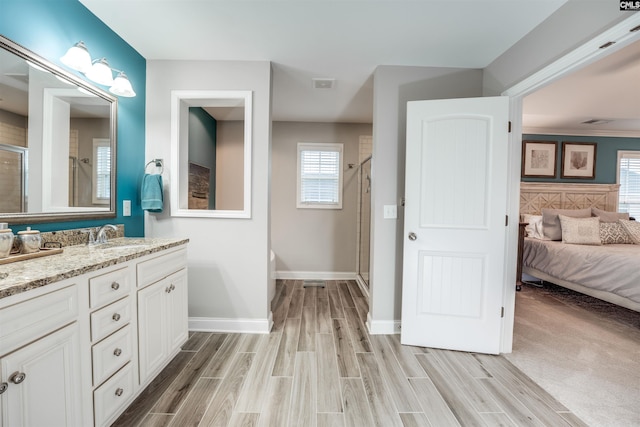 bathroom with vanity, a shower stall, baseboards, and wood tiled floor