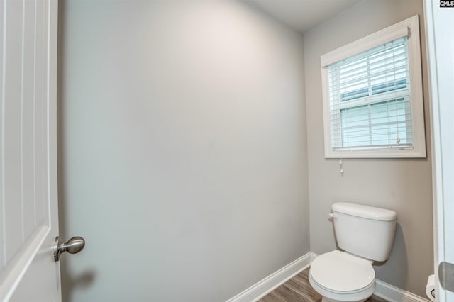 bathroom featuring toilet, baseboards, and wood finished floors