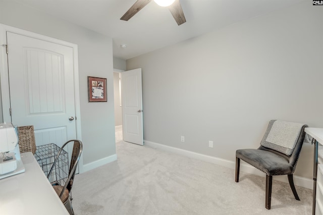 office space featuring baseboards, light colored carpet, and a ceiling fan