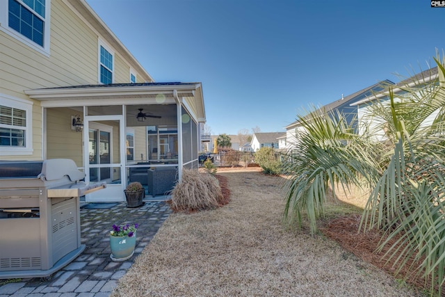 view of yard featuring a patio, fence, and a sunroom