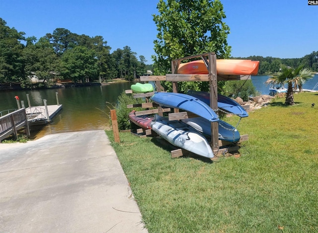 dock area with a lawn and a water view