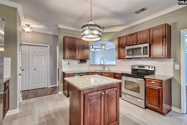 kitchen with tasteful backsplash, visible vents, a kitchen island, appliances with stainless steel finishes, and a sink