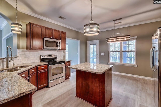 kitchen with light stone countertops, visible vents, a sink, appliances with stainless steel finishes, and backsplash