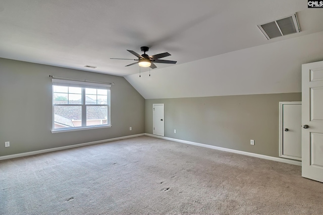 additional living space featuring visible vents, light colored carpet, and a ceiling fan