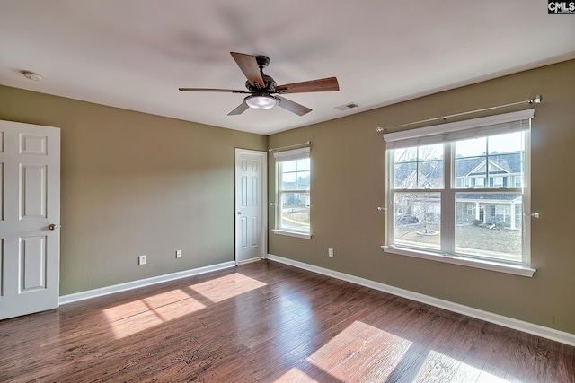 spare room with dark wood-style floors, baseboards, and ceiling fan