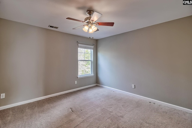 empty room with visible vents, carpet flooring, baseboards, and a ceiling fan