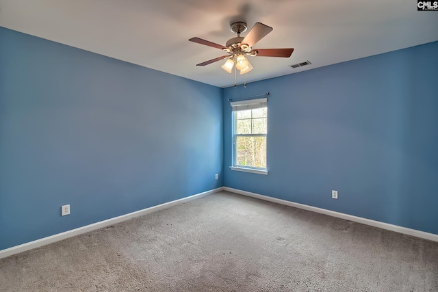 carpeted empty room featuring visible vents, a ceiling fan, and baseboards