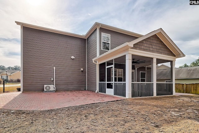 rear view of property featuring a patio, fence, and a sunroom