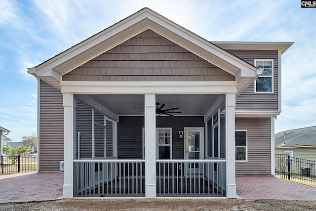 exterior space with fence, covered porch, and ceiling fan