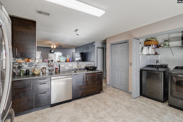 kitchen featuring a sink, washer and dryer, stainless steel appliances, dark brown cabinetry, and ceiling fan