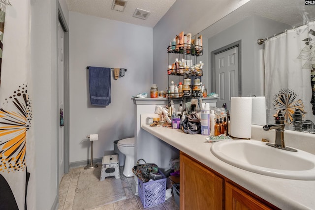 bathroom featuring visible vents, toilet, and a textured ceiling