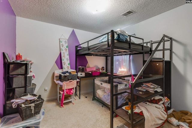 bedroom featuring visible vents, a textured ceiling, baseboards, and carpet floors