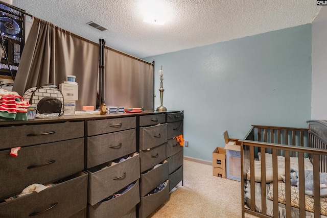 bedroom featuring visible vents, light carpet, a textured ceiling, and baseboards