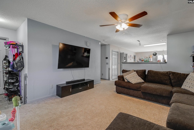 carpeted living room with baseboards, a textured ceiling, and a ceiling fan