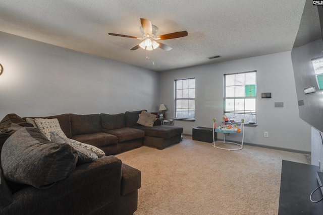 living room with visible vents, baseboards, carpet floors, a textured ceiling, and a ceiling fan