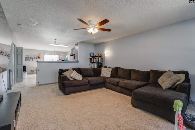 living area featuring light carpet, a textured ceiling, and a ceiling fan