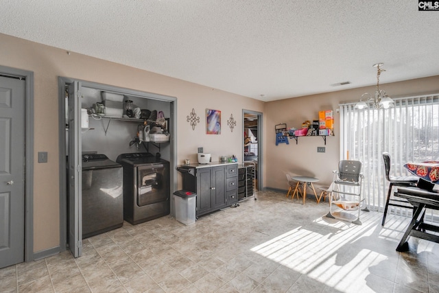 kitchen with visible vents, a textured ceiling, an inviting chandelier, and washing machine and dryer