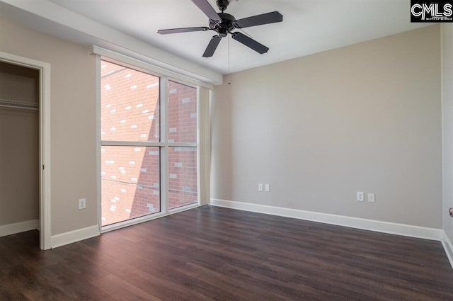 unfurnished bedroom featuring a closet, baseboards, dark wood-type flooring, and a ceiling fan