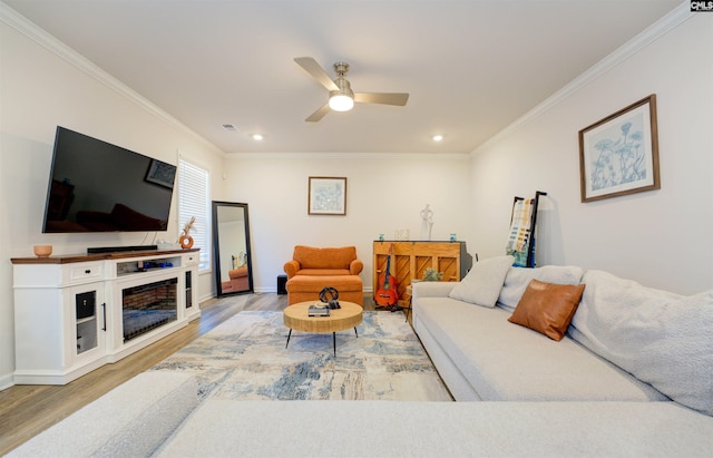 living area with ceiling fan, recessed lighting, light wood finished floors, and ornamental molding