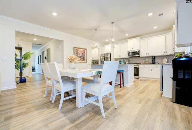 dining area with recessed lighting, visible vents, light wood-style flooring, and ornamental molding