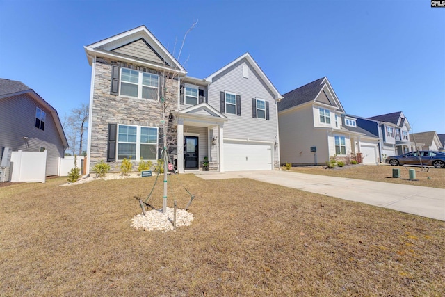 traditional-style house with fence, concrete driveway, a front yard, a garage, and stone siding