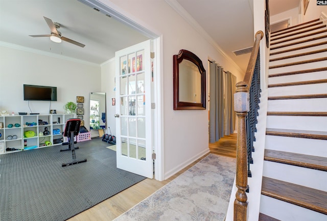 exercise room featuring visible vents, wood finished floors, ornamental molding, and a ceiling fan