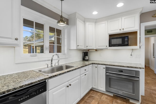 kitchen featuring decorative light fixtures, appliances with stainless steel finishes, white cabinetry, and a sink