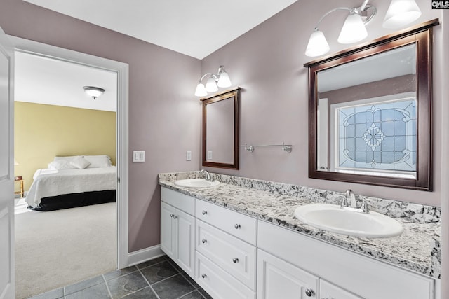 bathroom with double vanity, tile patterned flooring, ensuite bathroom, and a sink