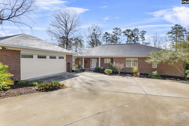 ranch-style house featuring a garage, brick siding, roof with shingles, and driveway