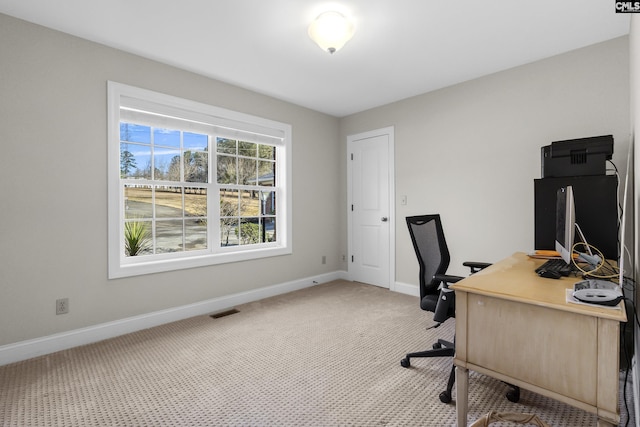 office featuring baseboards, visible vents, and light carpet