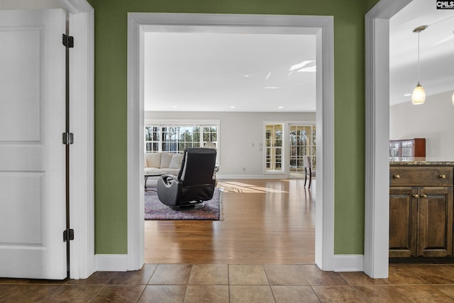 corridor featuring tile patterned floors, baseboards, and recessed lighting